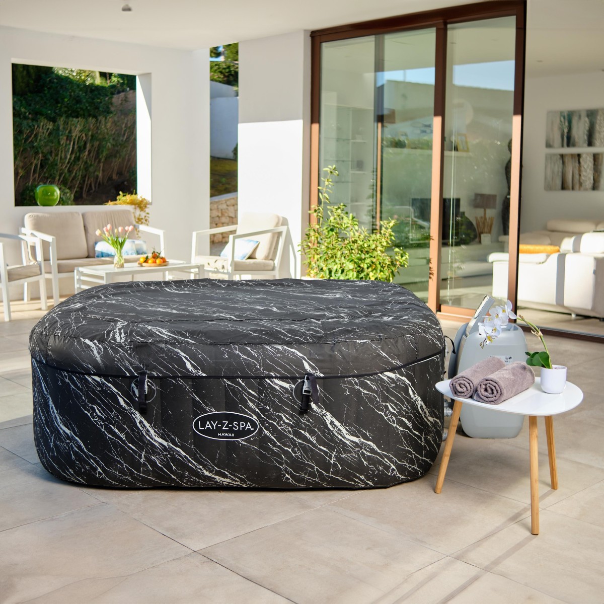 Jacuzzi z nałożoną ciemnoszarą, wzmocnioną pokrywą zabezpieczoną klamrami.